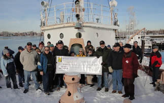 Members of NELL presenting a check aboard LV-112